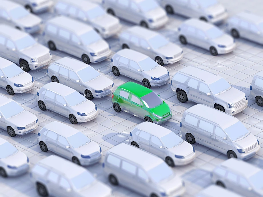 Zöld autó áll a fehér autók között